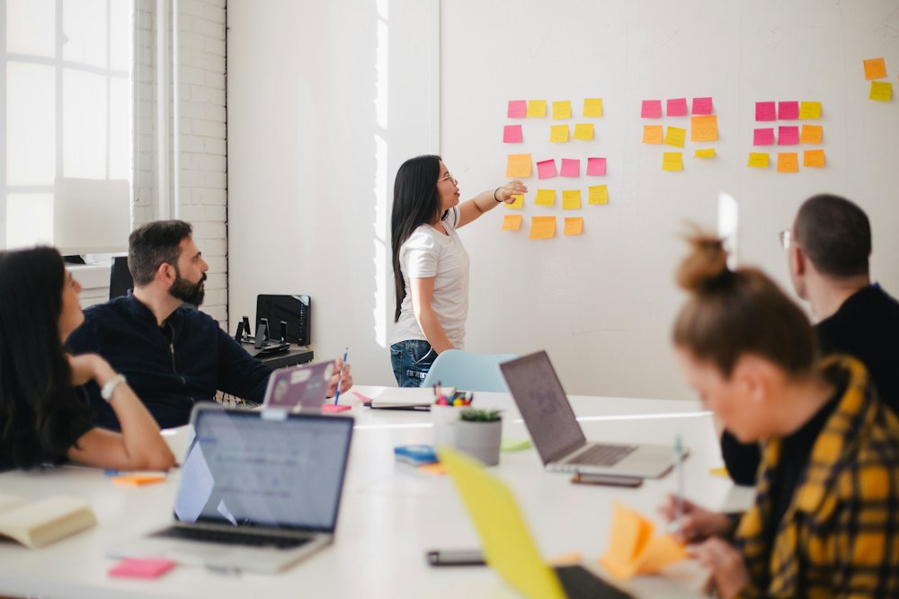 A team working through sticky notes on a wall during a workshop